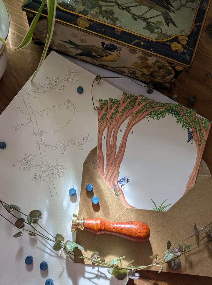 Un croquis d'un oiseau sur une branche, et une enveloppe d'où s'échappent des jolis notes ornées d'arbres et d'oiseaux